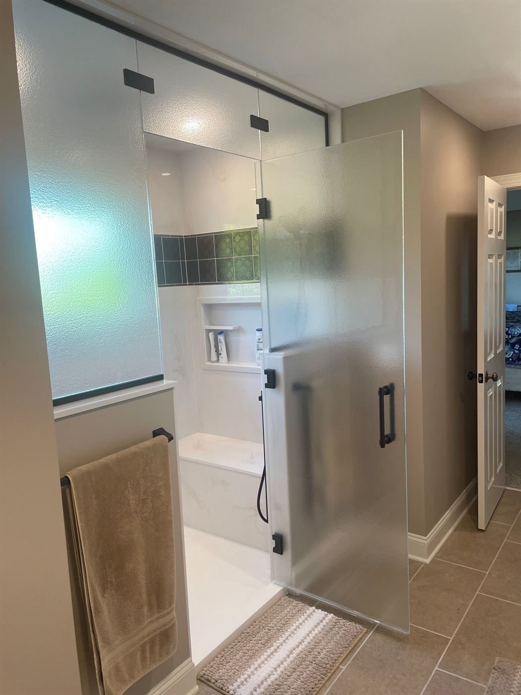Walk-in tile shower with frosted glass by Stellar Construction