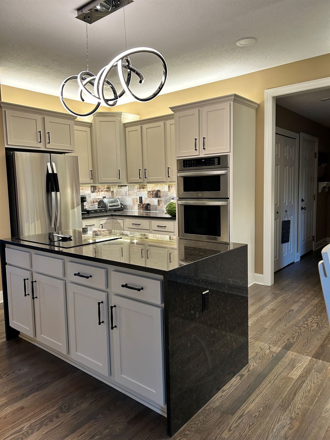 Kitchen remodel with island and sculptural lighting by Stellar Construction